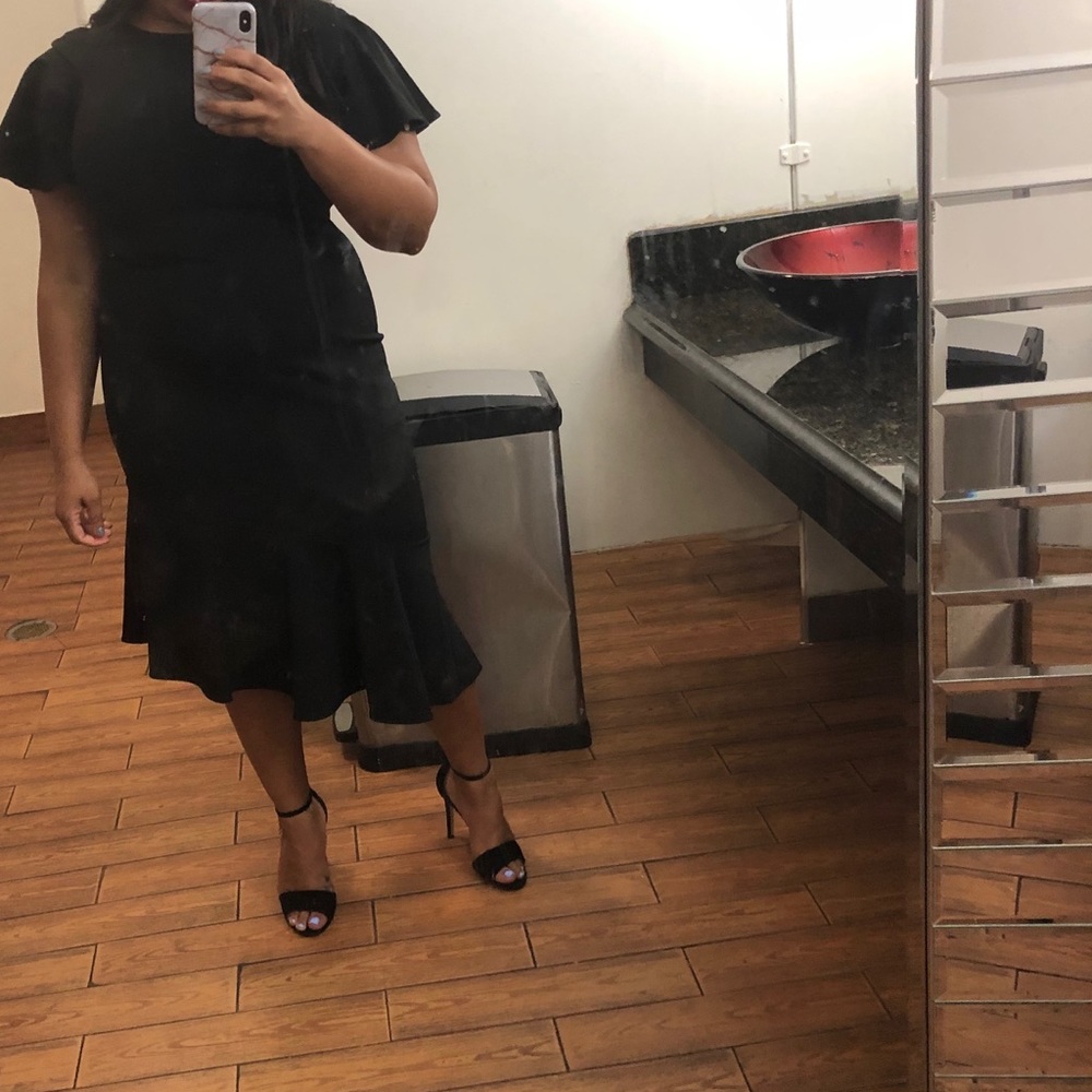 Black dress with slanted ruffled bottom.